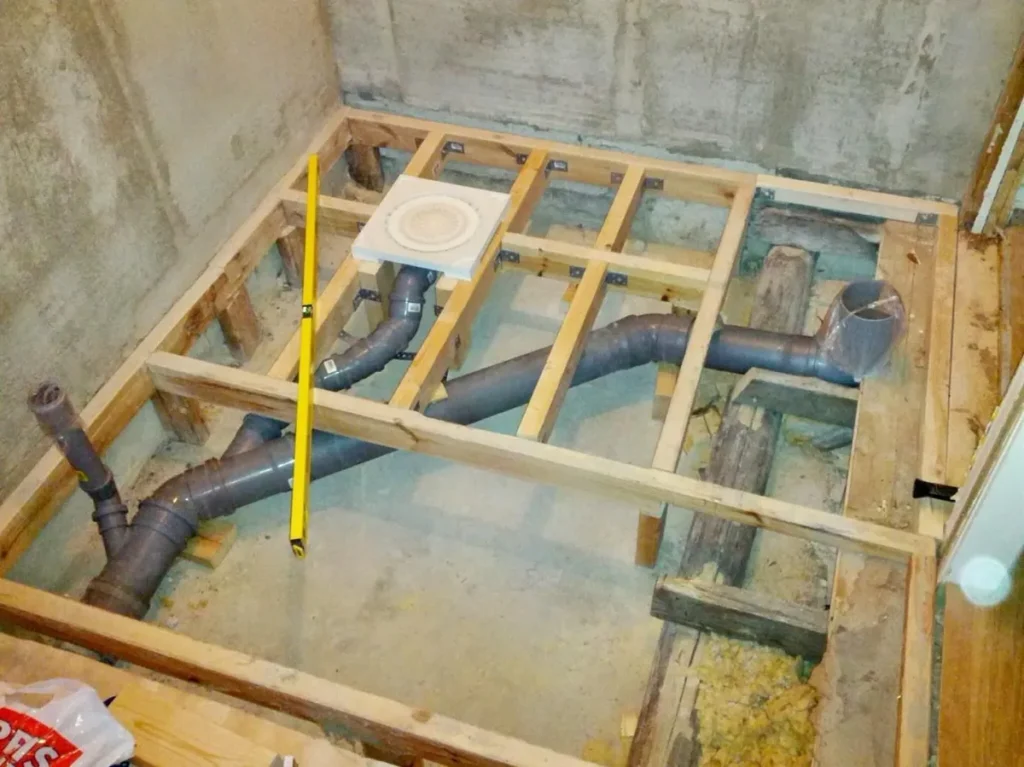 Bathroom drainage and waste pipework installation during a bathroom renovation, showing new plumbing beneath the floor.