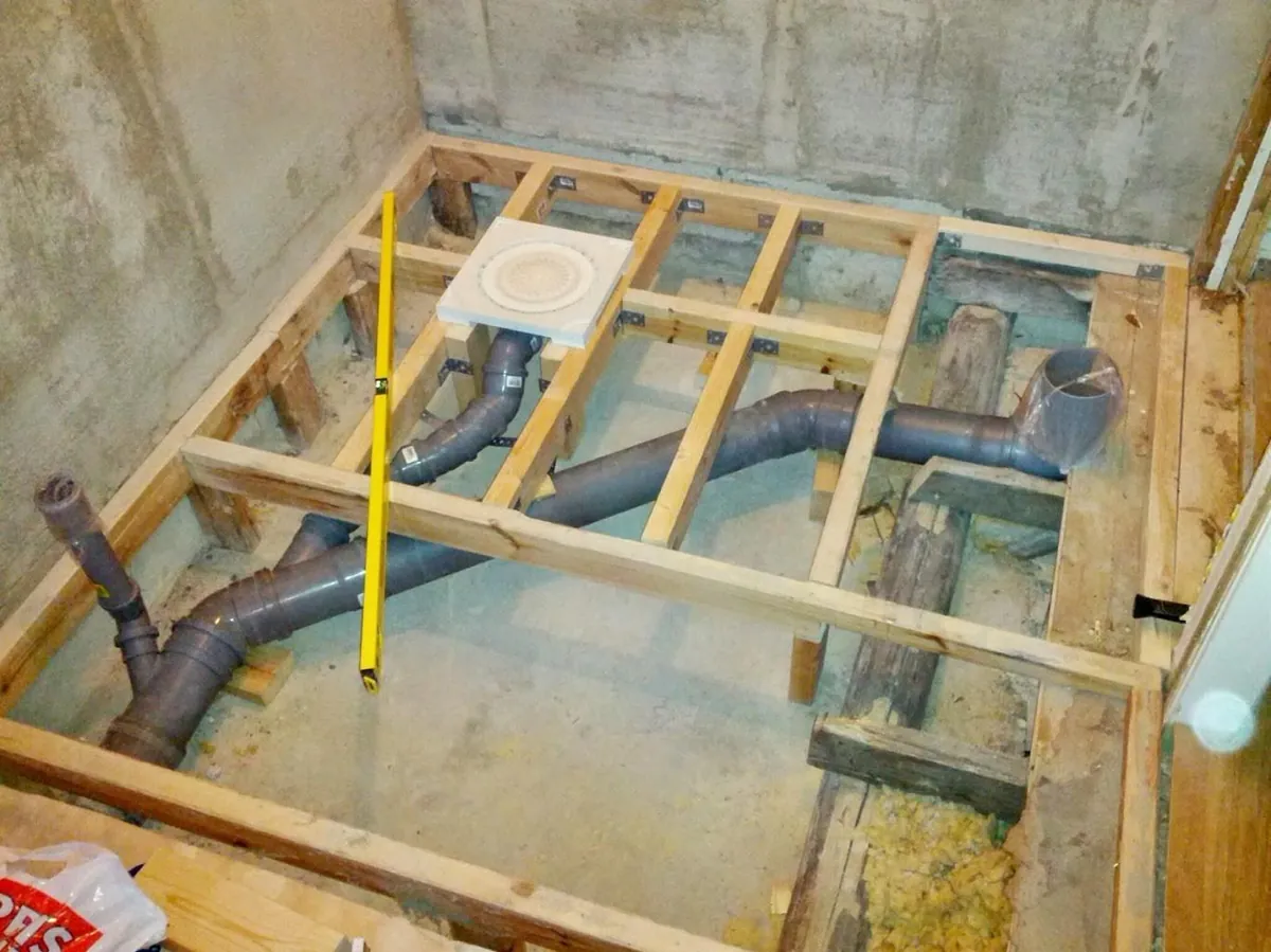Bathroom drainage and waste pipework installation during a bathroom renovation, showing new plumbing beneath the floor.
